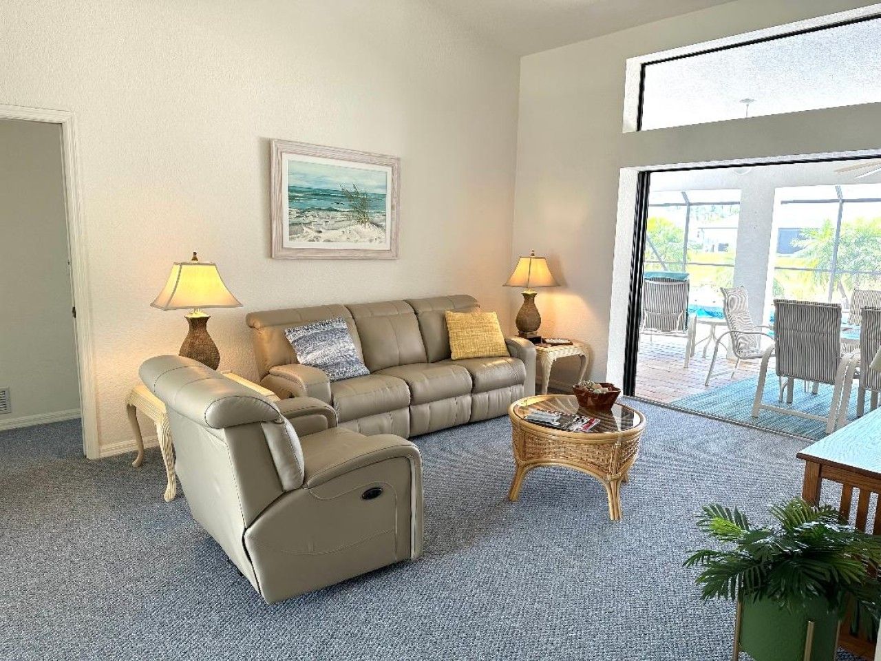 A living room with a sofa set, two lamps, a coffee table, and a painting on the wall.