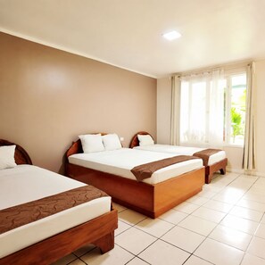 A hotel room with two beds, a window with curtains, and a tiled floor. - Toucan Arenal Lodge (La Fortuna)