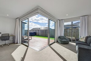 A modern living room with a large sliding glass door leading to a patio area.