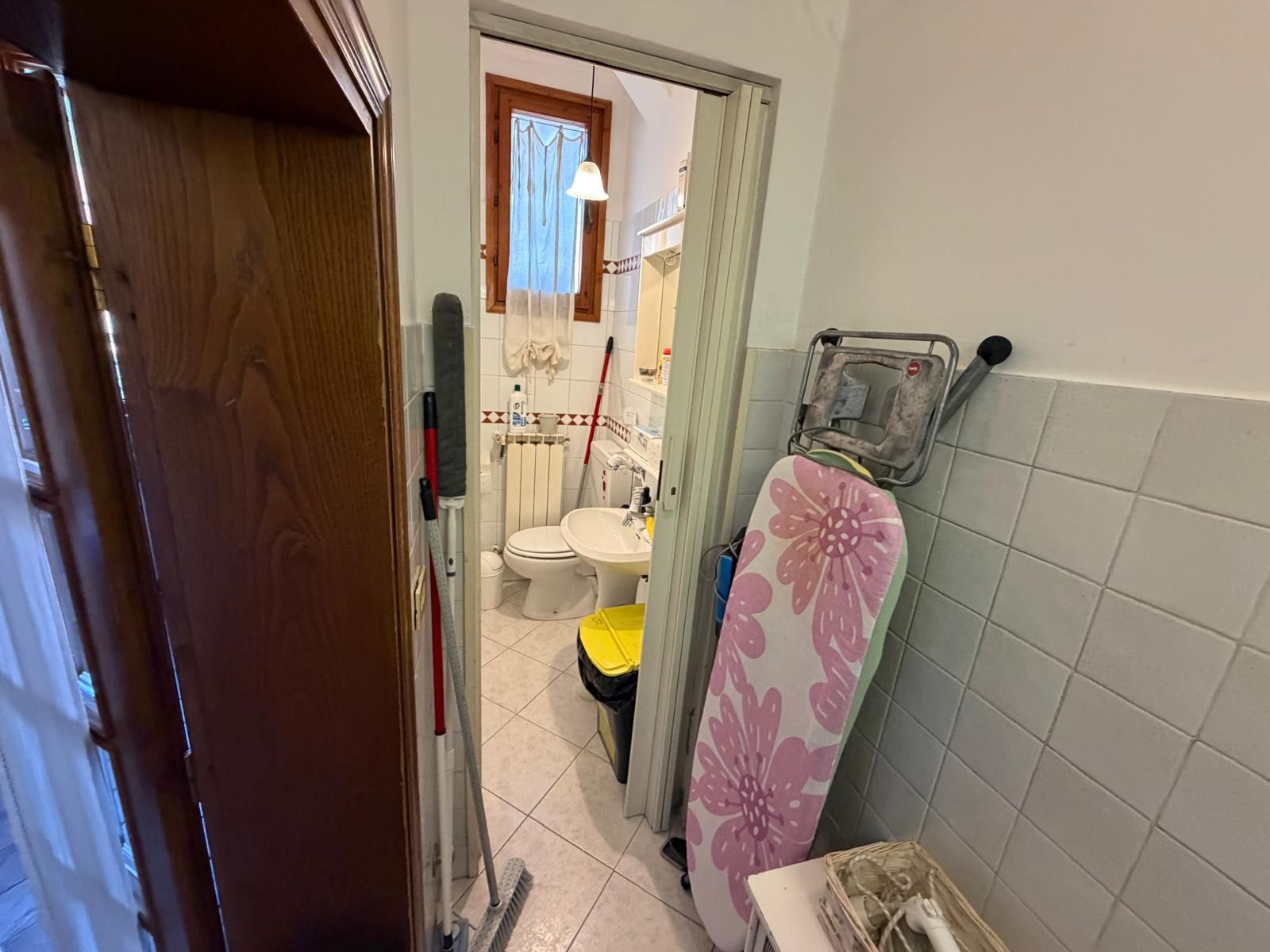 Un baño pequeño con inodoro, lavamanos y zona de ducha.