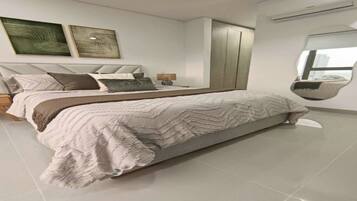 A modern bedroom with a large bed, a wardrobe, and two wall-mounted artworks.