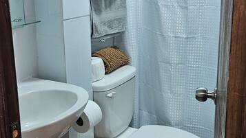 A bathroom with a toilet, bidet, and a sink.