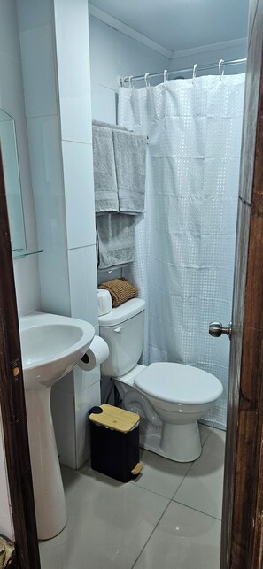 Une salle de bain équipée de toilettes, d’un bidet et d’un lavabo.