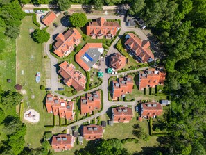 An aerial view of a residential area with multiple houses, green lawns, and a playground. - 4.5/t3 in the "freesenbruch" Holiday Park (Zingst)
