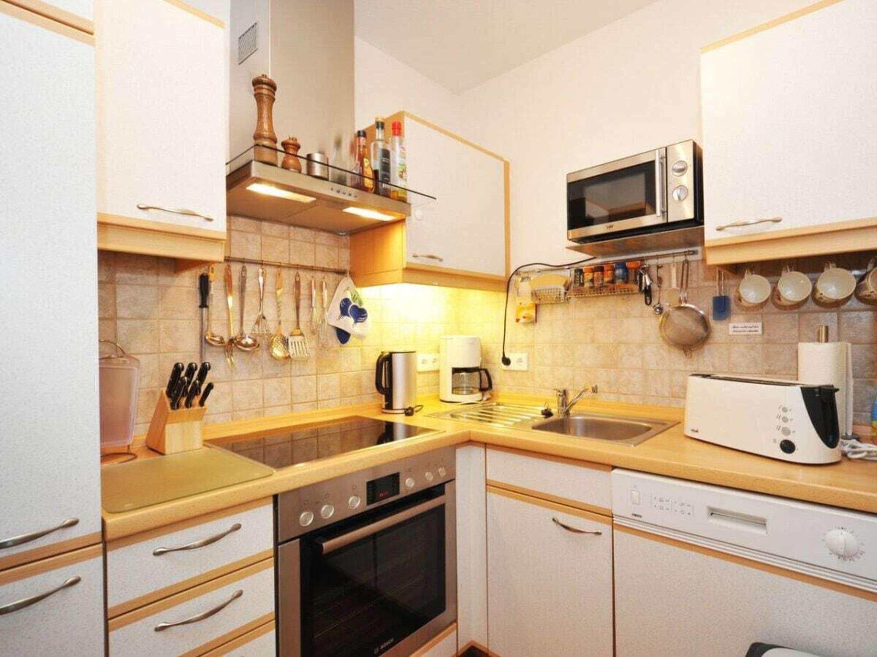 A compact kitchen with a microwave, stove, and dishwasher.
