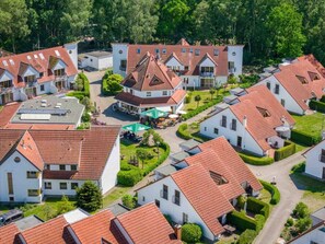 A residential area with multiple houses, each featuring a red-tiled roof and white walls. - 4.5/t3 in the "freesenbruch" Holiday Park (Zingst)