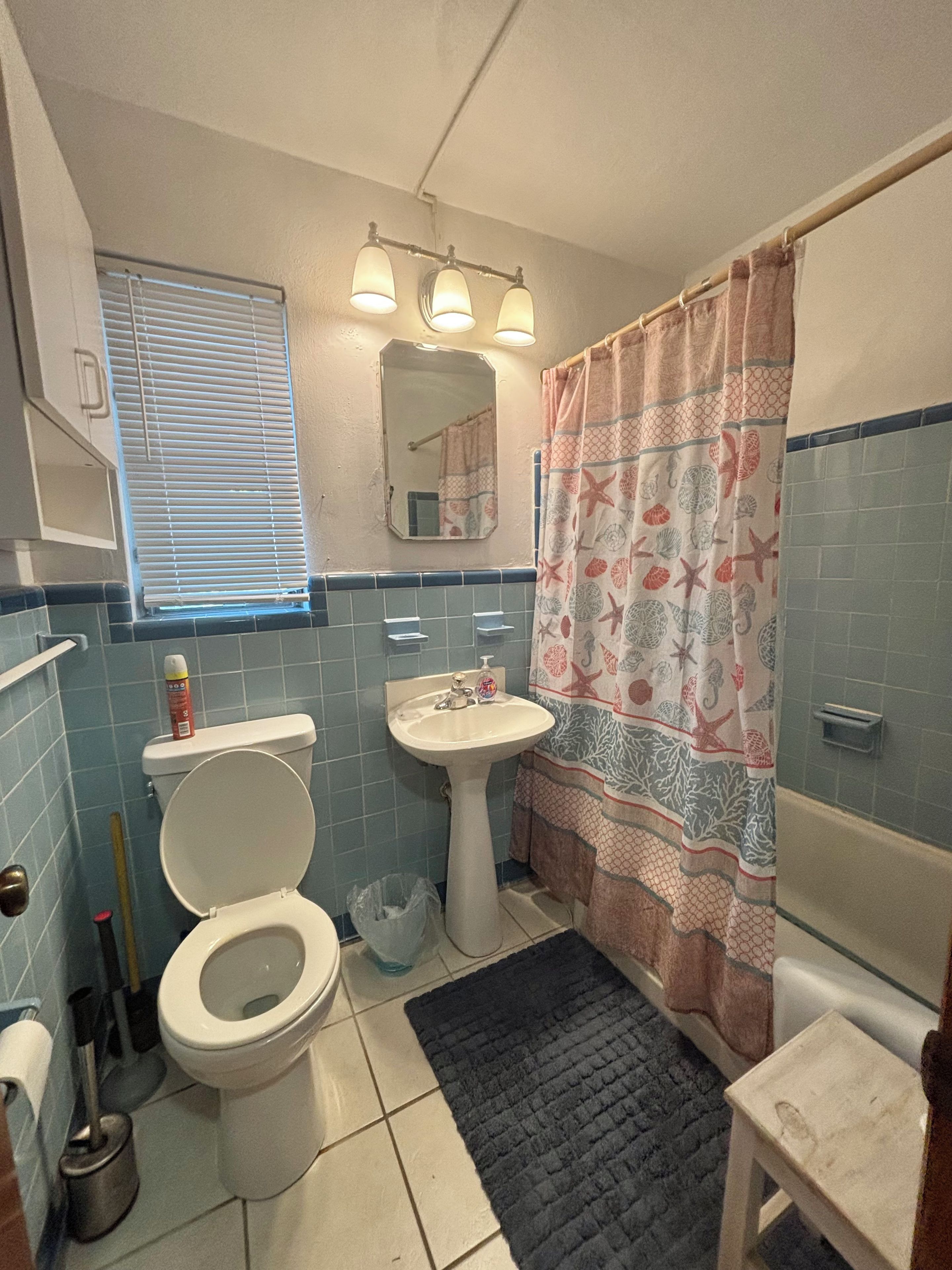 A bathroom with a toilet, sink, and shower area.