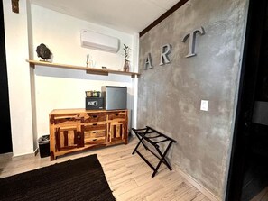 A room with a wooden cabinet, a small table, and a wall with the word 'ART' on it.