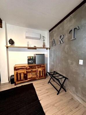 A room with a wooden cabinet, a television, and a wall with the word 'ART' on it.