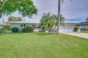 A single-story house with a front yard, a garage, and a small garden area. - The Cape Escape | Cape Coral (Cape Coral)