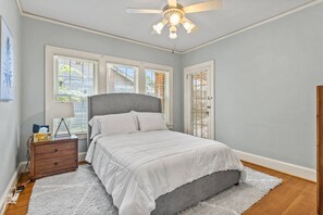 A bedroom with a bed, a nightstand, a lamp, and a ceiling fan. - Downtown 3-bedroom Near HPU & Furniture Market (High Point)