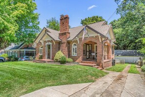 A single-story brick house with a front porch, a chimney, and a garage. - Downtown 3-bedroom Near HPU & Furniture Market (High Point)