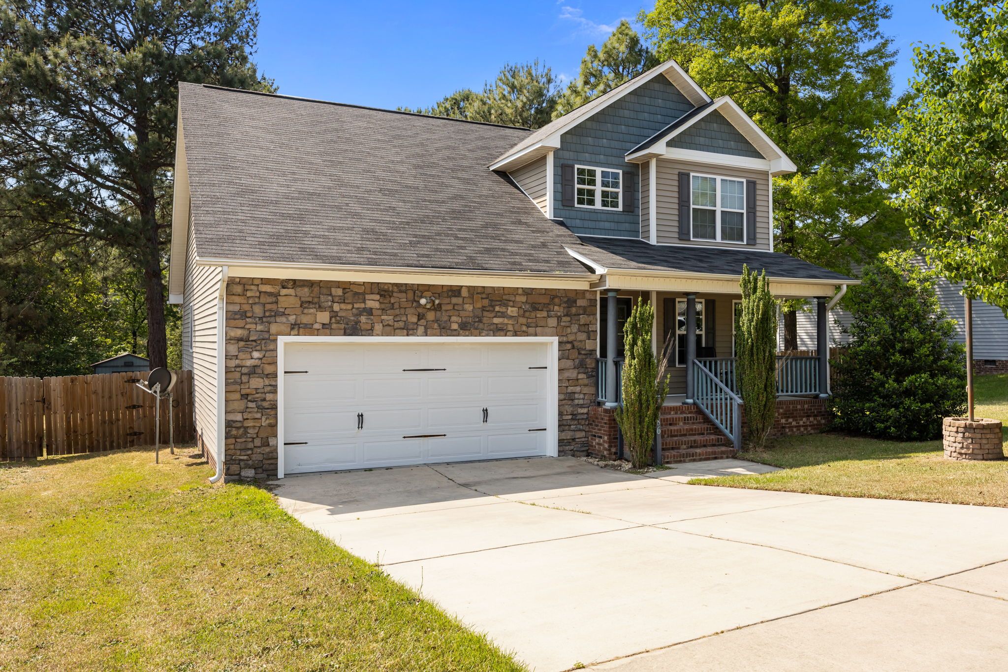 A two-story house with a stone facade, a garage, and a front porch.