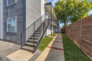 Un edificio moderno con una escalera metálica que conduce a una entrada con puerta.