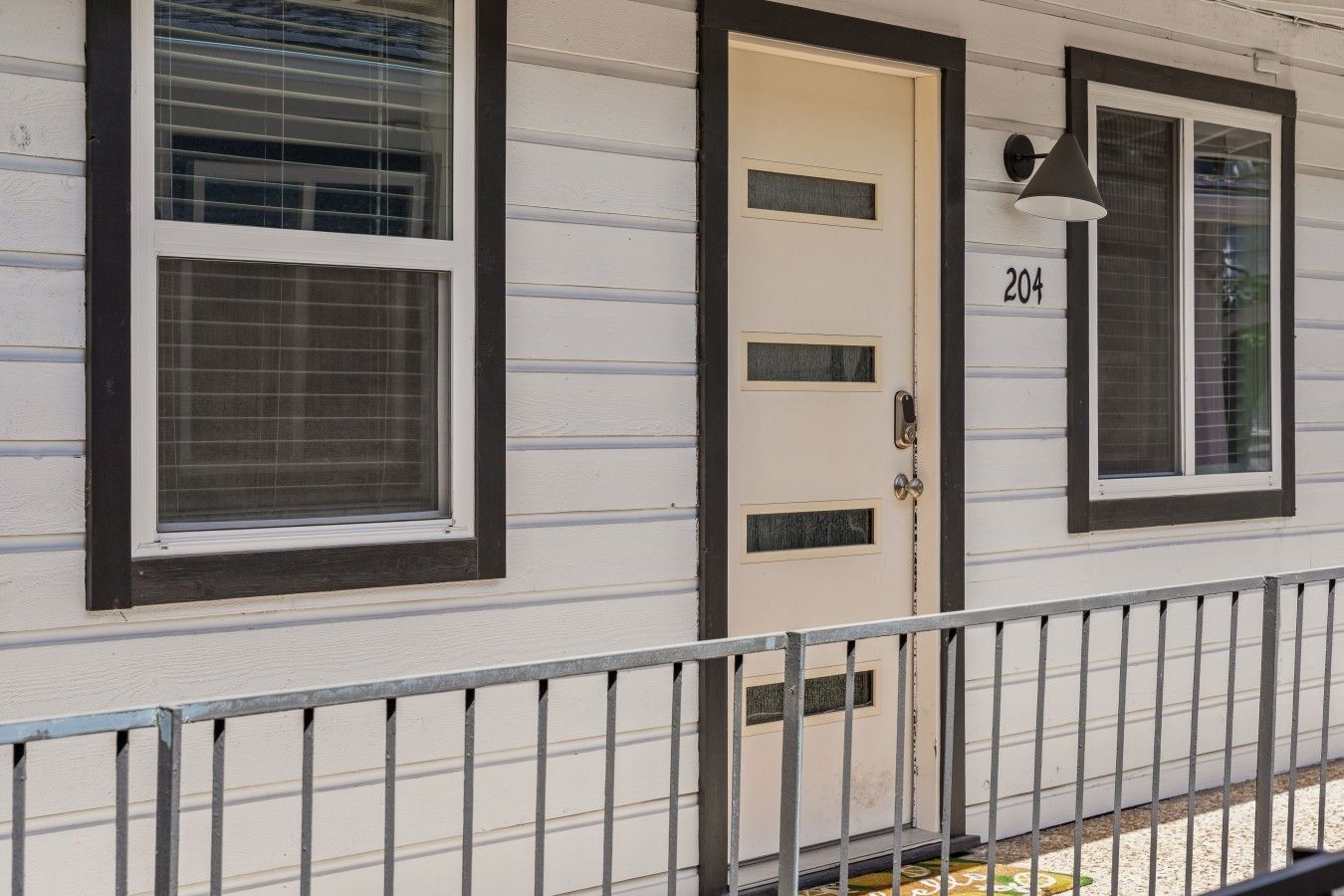 A house with a beige door, a number '204' above it, and a window with a black frame.