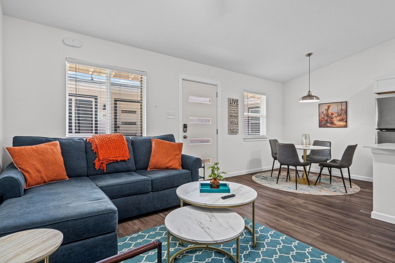 A modern living room with a sofa, coffee table, and dining area.
