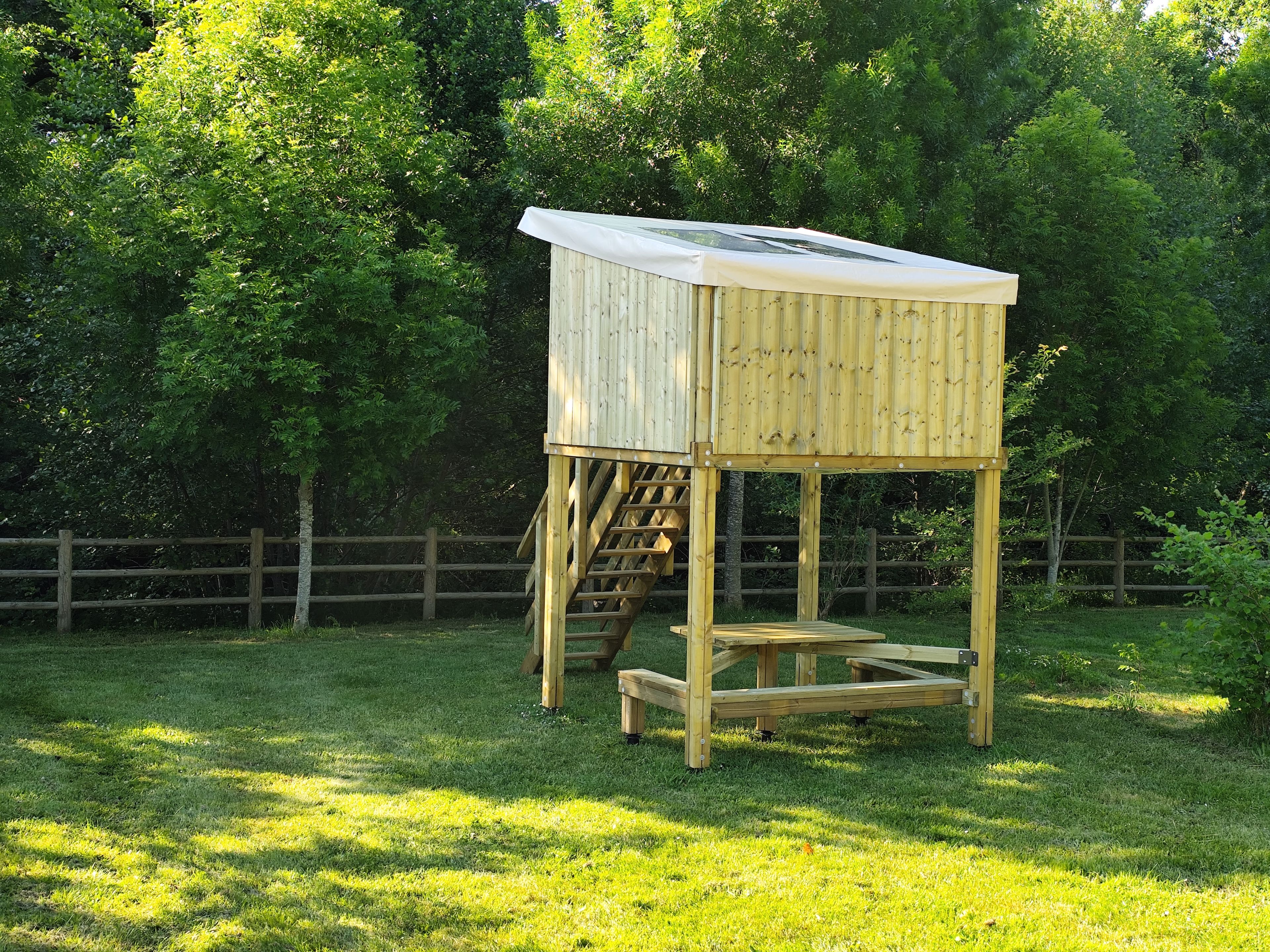 Une maison de jeu en bois, dotée d’un toit et d’un escalier.