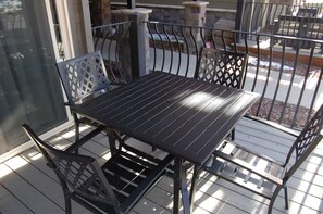 A balcony with a metal table and chairs, a glass door, and a view of the outdoors. - Marvelous 2-bedroom condo in Crested Butte for your getaway (Crested Butte)