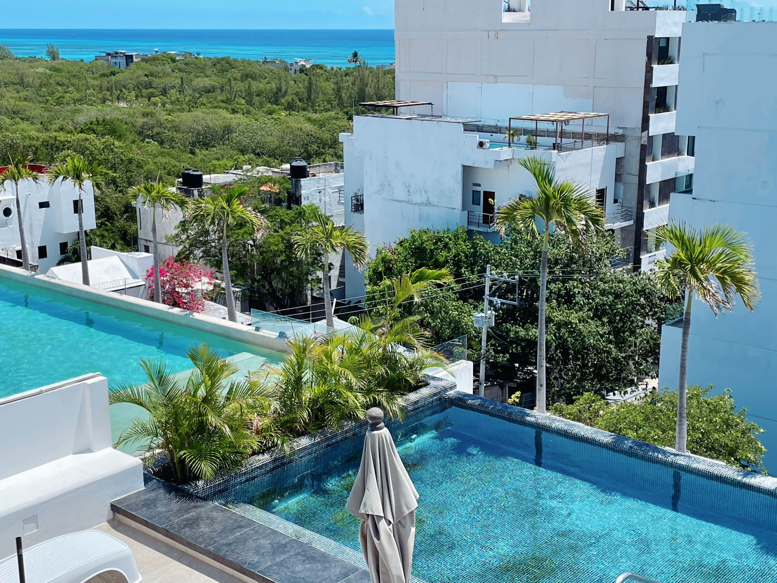 Ein Dachpool mit Blick auf den Ozean und die umliegenden Gebäude.