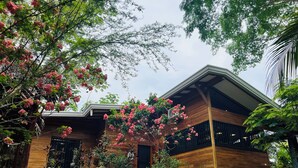 Un edificio residencial con techo inclinado, revestimiento de madera y porche delantero.