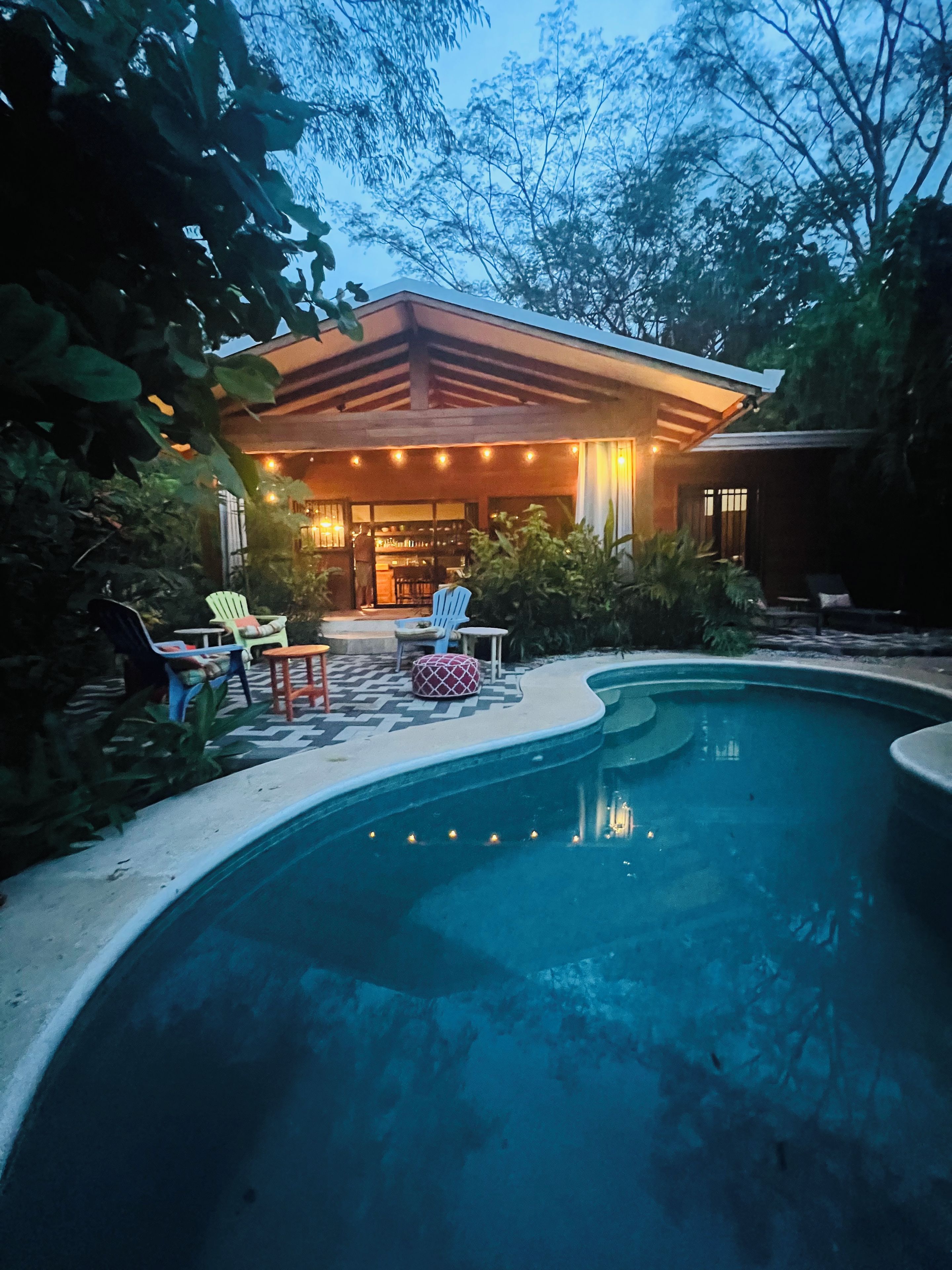 A swimming pool with lounge chairs and a covered patio area.