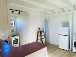 Une cuisine avec un réfrigérateur blanc, une cuisinière et un lave-linge.