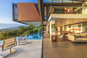 Uma casa moderna com piscina, área de estar externa e espaço para refeições.