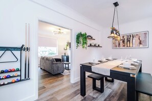 Ein Essbereich mit einem Tisch für vier Personen, einer hängenden Pflanze und einem Bild an der Wand.