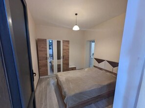 Une chambre à coucher avec un lit, une armoire et un miroir.