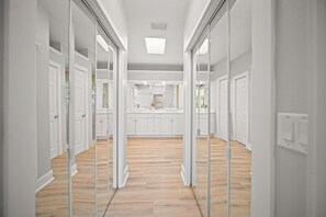 A hallway with mirrored walls, a central kitchen area, and a light-colored wooden floor. - About a 9 min walk to St. Augustine Beach, with easy day trips up the coast (St. Augustine)