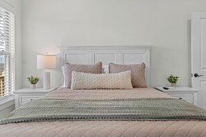 A neatly arranged bedroom with a bed, two bedside tables, a lamp, and a window with blinds. - 3-bedroom house in charming Bella Vista with AC for relaxing stays (Bella Vista)