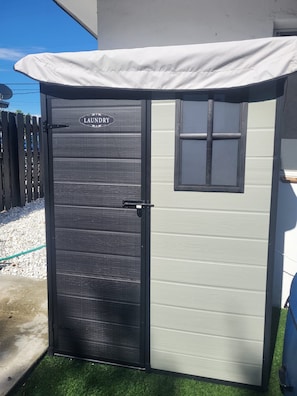 A grey laundry room with a door and a small window.
