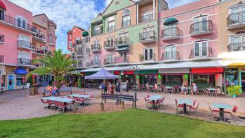 Un patio con asientos al aire libre, rodeado de edificios coloridos con balcones.