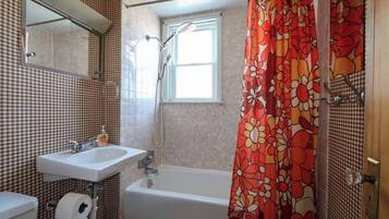 Un baño con ducha, lavabo e inodoro.