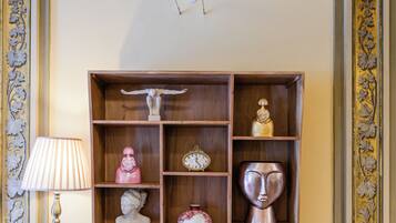 Una habitación con una estantería de madera que contiene varios objetos decorativos y libros.