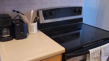 Una cucina con un fornello, un forno e una macchina da caffè sul piano di lavoro.