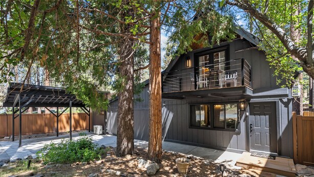 A two-story cabin with a balcony, surrounded by trees and a wooden deck. - Big bear hideaway/ hot tub/ pool table/4br near snow summit (Big Bear Lake)