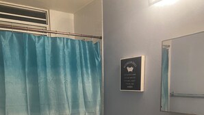 A bathroom with a toilet, sink, and a blue shower curtain. - Charming 3-bedroom apartment minutes from beach in fajardo ! (Fajardo)