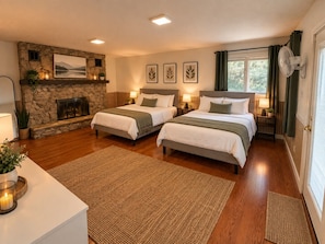 A hotel room with two beds, a stone fireplace, and a view of the outdoors. - Spacious Rockford Home | 4BR • 7 Beds • 4.5BA (Rockford)