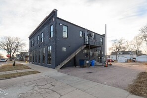 A two-story building with large windows and a staircase leading to the second floor.
