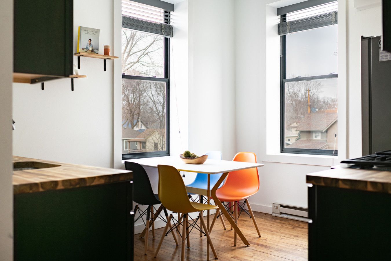 Una cocina moderna con una mesa de comedor y sillas, ventanas amplias y vistas al exterior.