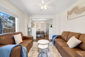 A living room with two brown leather sofas, a white coffee table, and a ceiling fan. - Spacious 4BR • 5 Bds •2Bts Ranch for Mid Term Stay (Rockford)