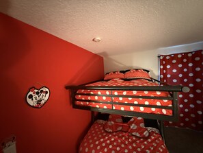 A bunk bed with red bedding and a Mickey Mouse wall decoration. - Villa Bella Sol, 5BR, Sleeps 14, Pool/ Spa, Disney (Davenport)