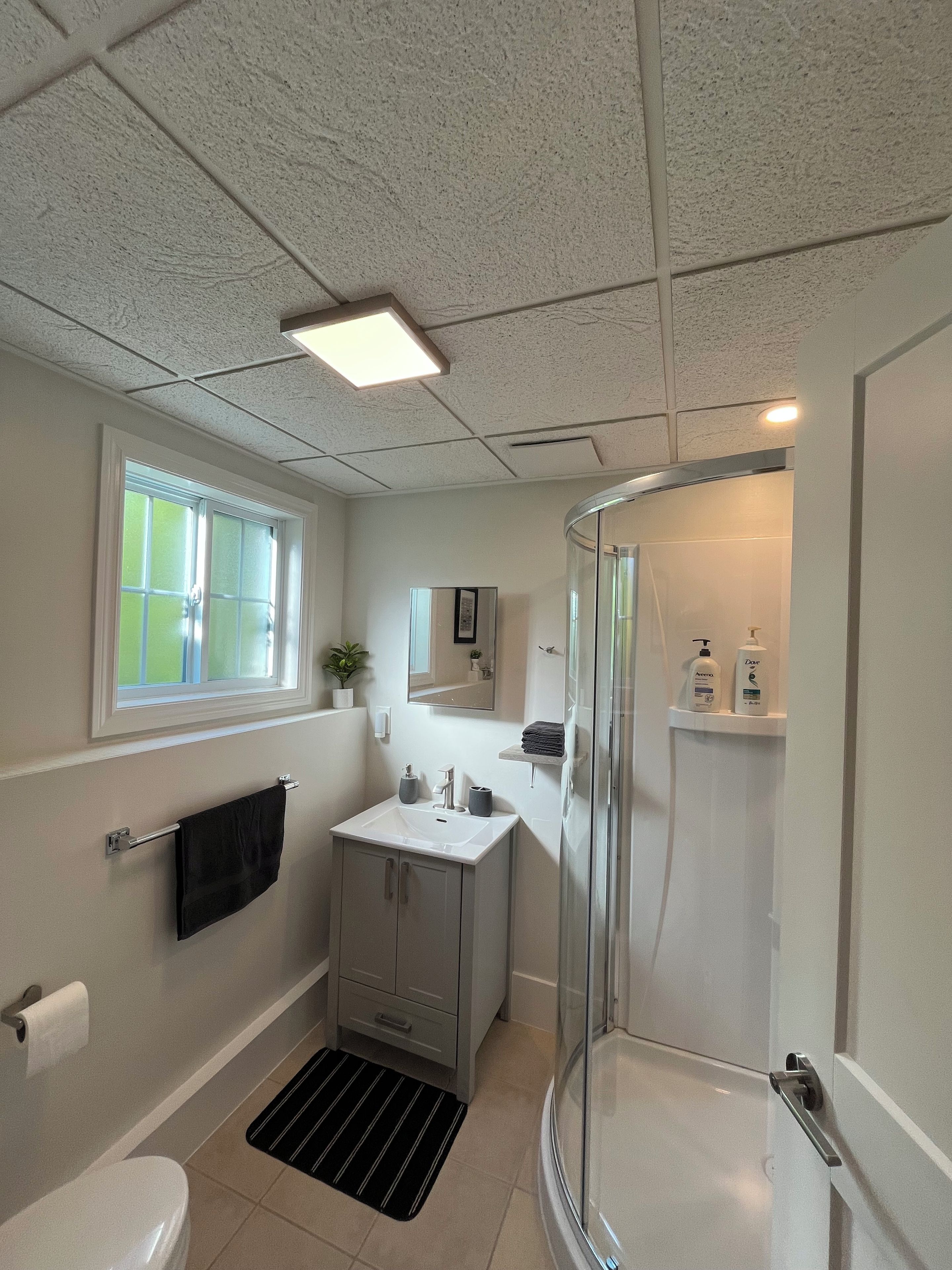 A modern bathroom with a toilet, sink, and shower.