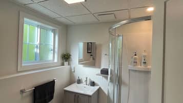 A modern bathroom with a toilet, sink, and shower.
