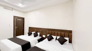 A hotel room with two beds, a wooden headboard, and a ceiling fan.