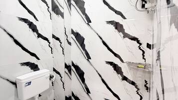 A bathroom with a toilet, bidet, and a shower area.