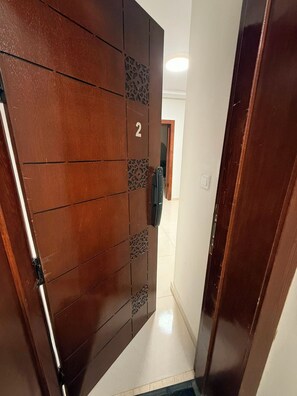 A wooden door with a number '2' indicating a room or apartment number, a keypad lock, and a small decorative panel.