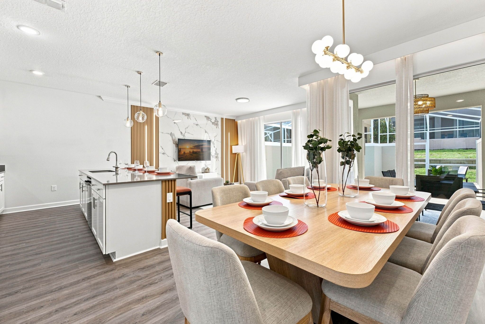 A modern dining area with a wooden table set for six, surrounded by chairs.