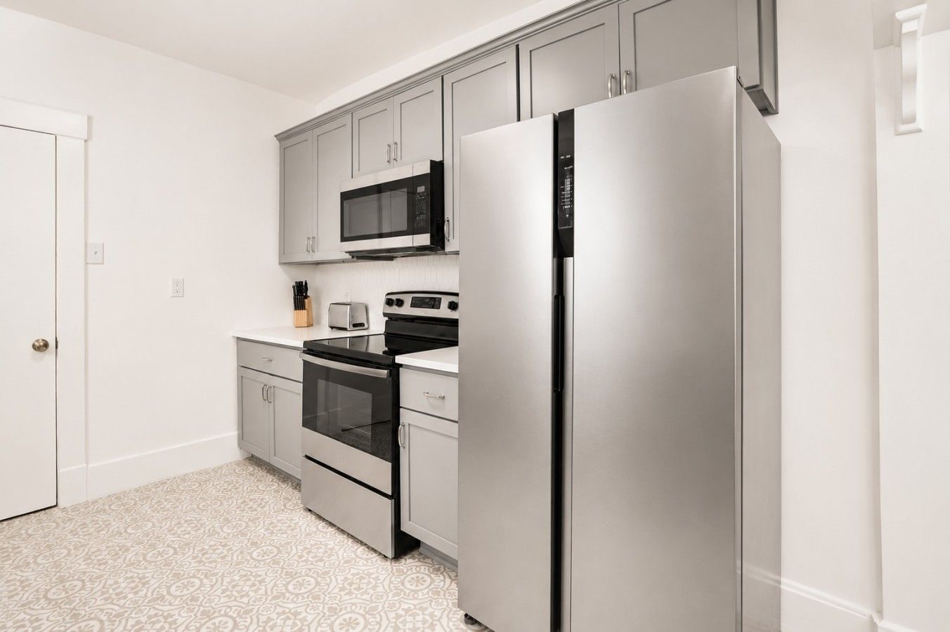 Una cocina moderna con electrodomésticos de acero inoxidable, microondas, horno y refrigerador.